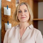 Portrait of a confident businesswoman with blonde hair in a modern office.